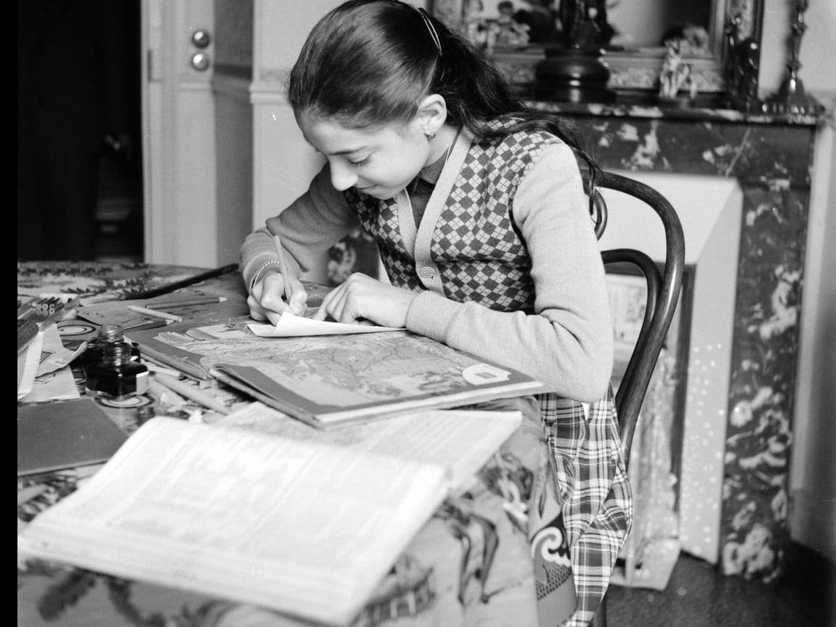 Een meisje maakt aan tafel haar huiswerk, 1950