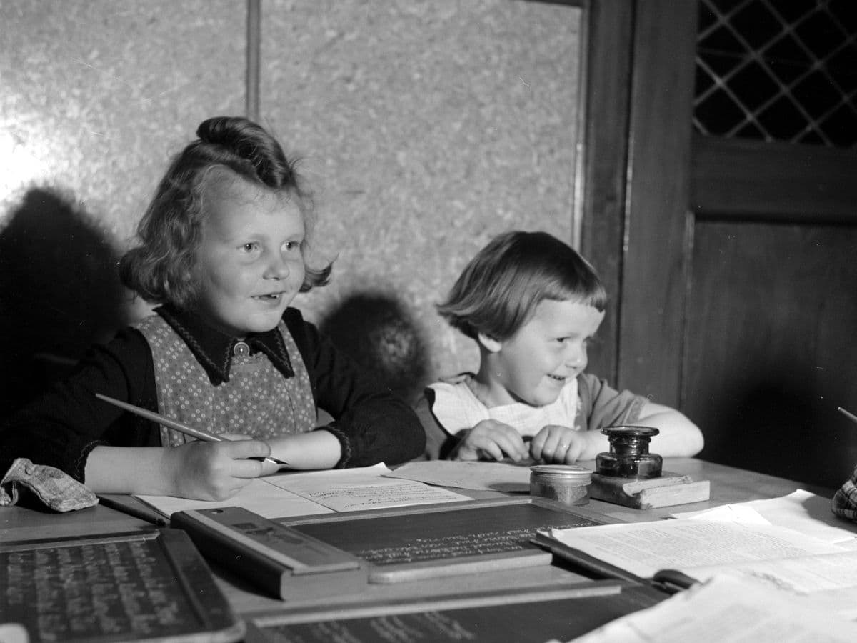 Twee meisjes leren samen schrijven met een kroontjespen, 1955